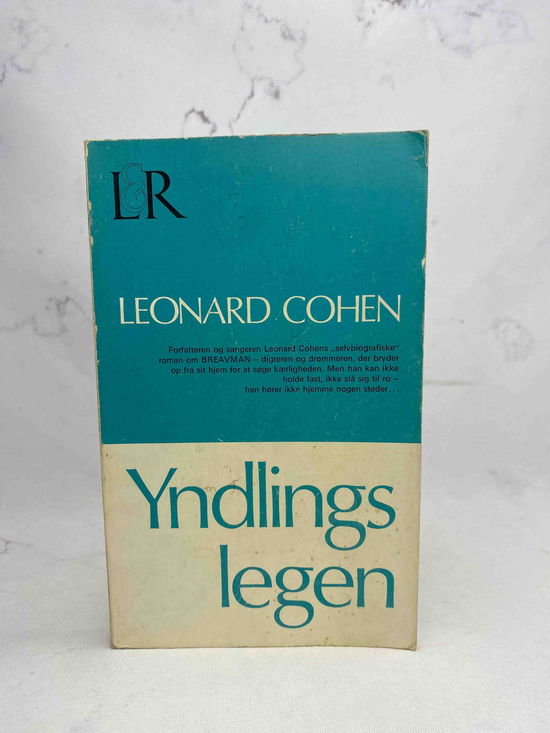 Cover for Leonard Cohen · Yndlingslegen (Sewn Spine Book) [1st edition] (2025)