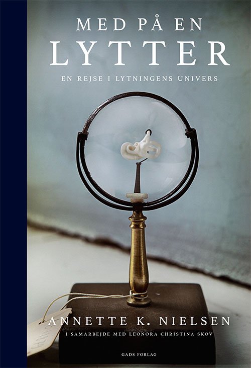 Cover for Annette K. Nielsen i samarbejde med Leonora Christina Skov · Med på en lytter (Hardcover Book) [1º edição] (2022)