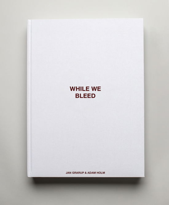 Cover for Jan Grarup and Adam Holm · WHILE WE BLEED - The limited edition (Innbunden bok) (2023)